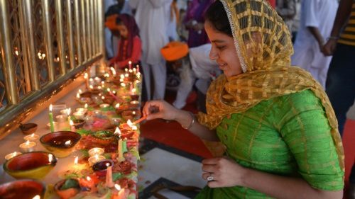 Woman in India lights a lamp for Deepavali 