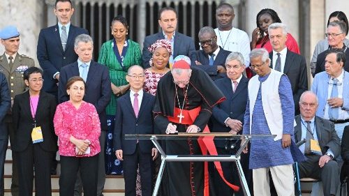 Cardinal Pietro Parolin (C) surrounded by Nobel Peace Prize winners, signs the "Declaration on Human Fraternity" during the "NotAlone World Fraternity" meeting in St.Peter's square at the Vatican, on June 10, 2023. Nobel Peace Prize winner Maria Ressa stands with fellow Nobel laureates (2nd from the left). (Photo by Alberto PIZZOLI / AFP)