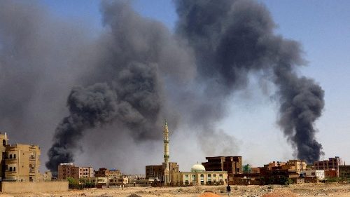 FILE PHOTO: Man walks while smoke rises above buildings after aerial bombardment in Khartoum North Sudan. May 1, 2023.