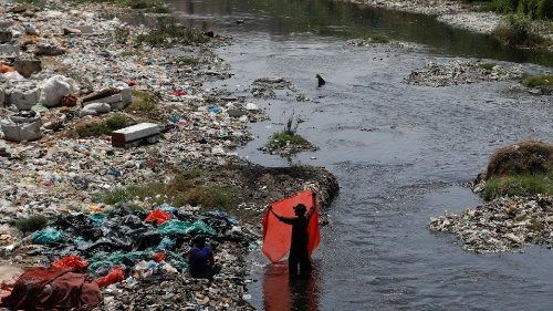 FILE: A man washes waste plastic sheets, collected for recycling, on World Environment Day in Karachi. REUTERS/Akhtar Soomro