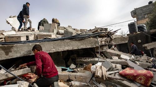 Palestinian children search amid the rubble following Israeli airstrikes in Rafah